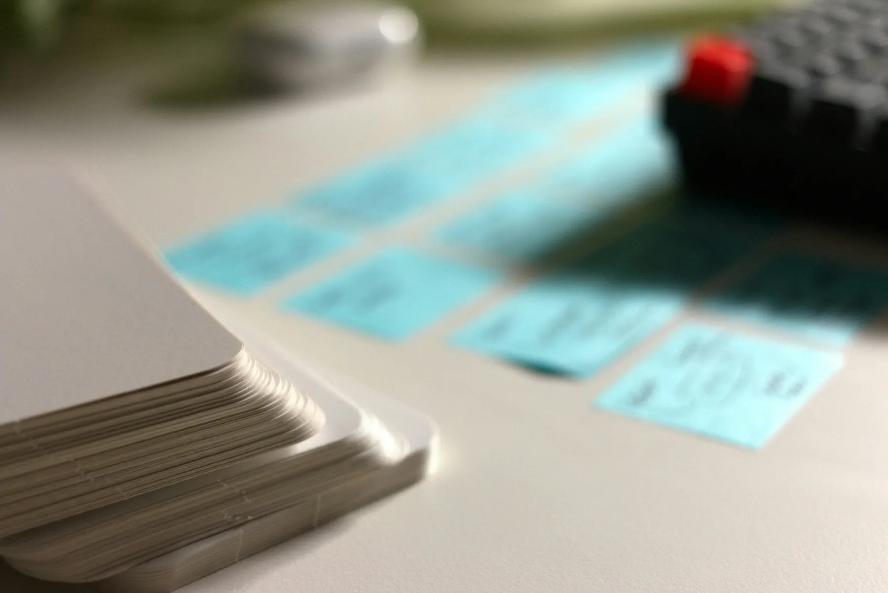 Un mazo de tarjetas de estudio en blanco con notas adhesivas azules al fondo.